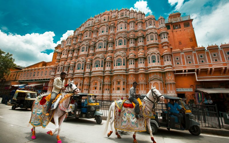 men riding horse infront of hawa mahal in jaipur